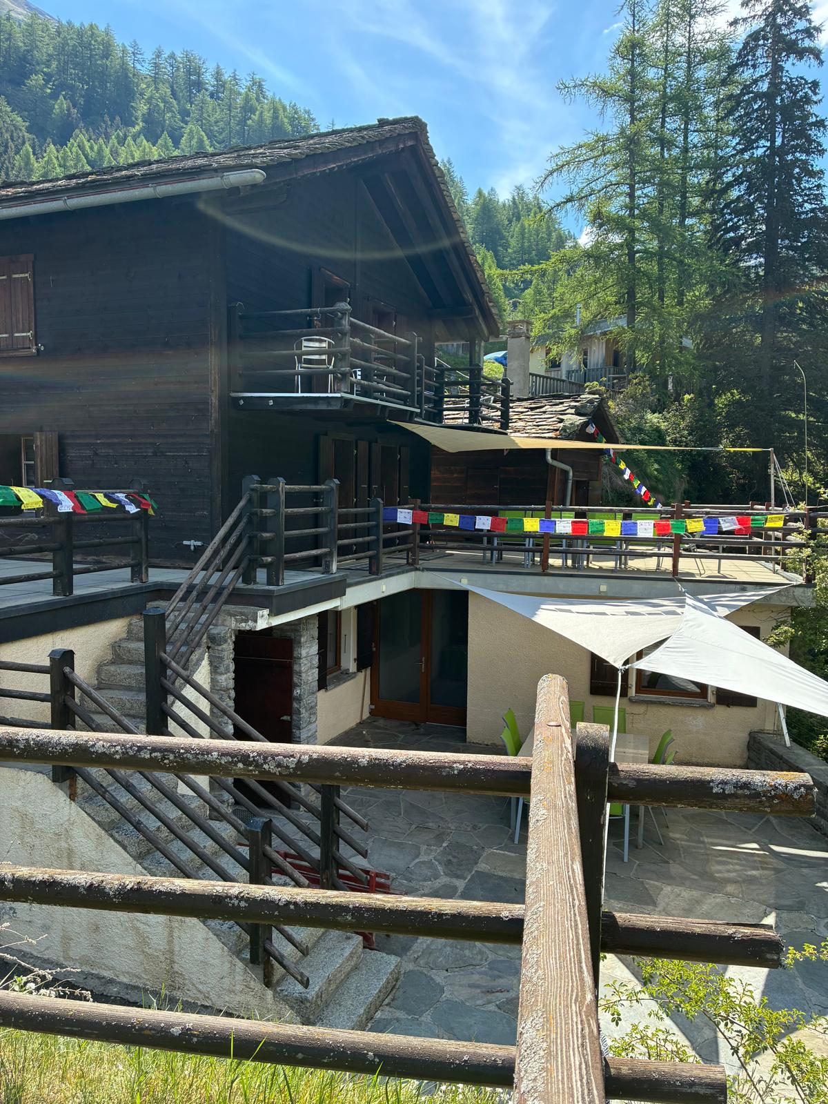 Le chalet Blue Hébergement et sa terrasse ornée de drapeaux de prière, Bourg-Saint-Pierre